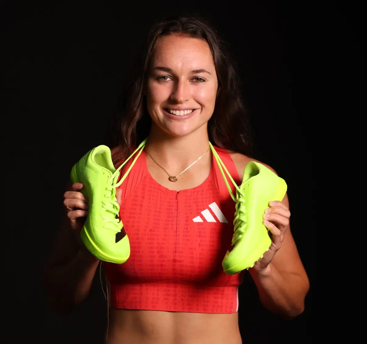 Brynn King smiles with adidas shoes around her neck