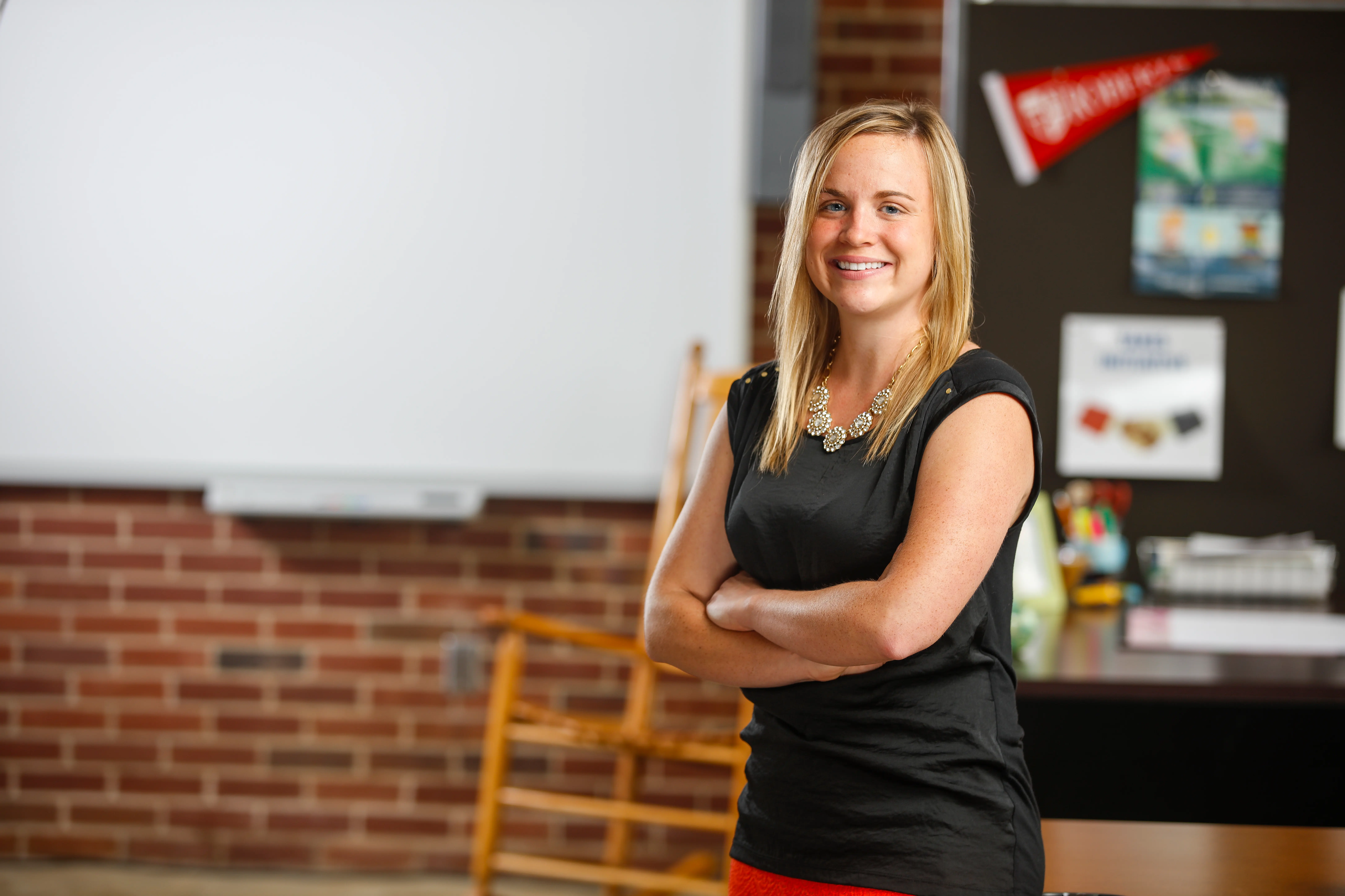 A woman smiles with her arms crossed