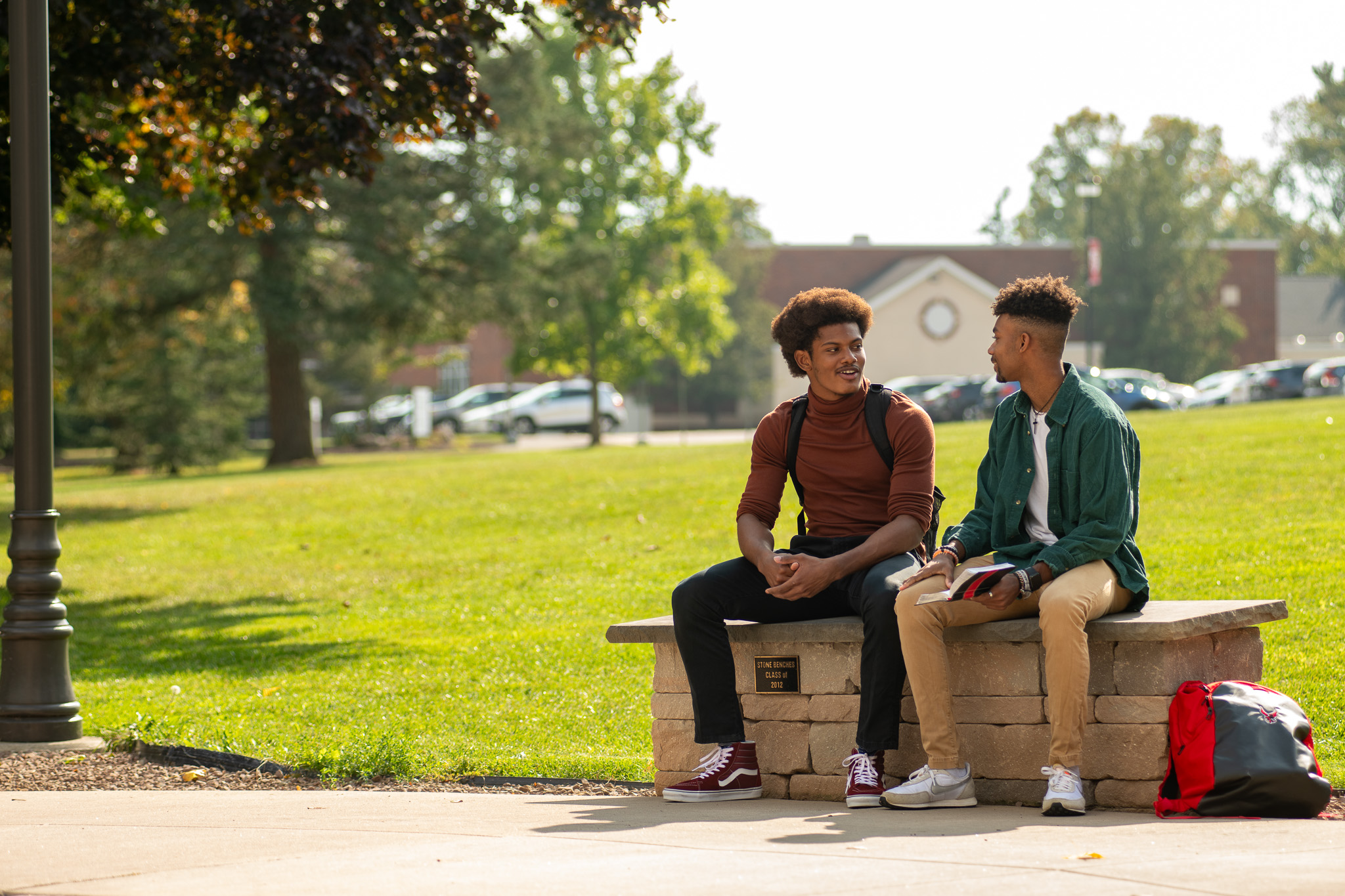 Two students sit outside together