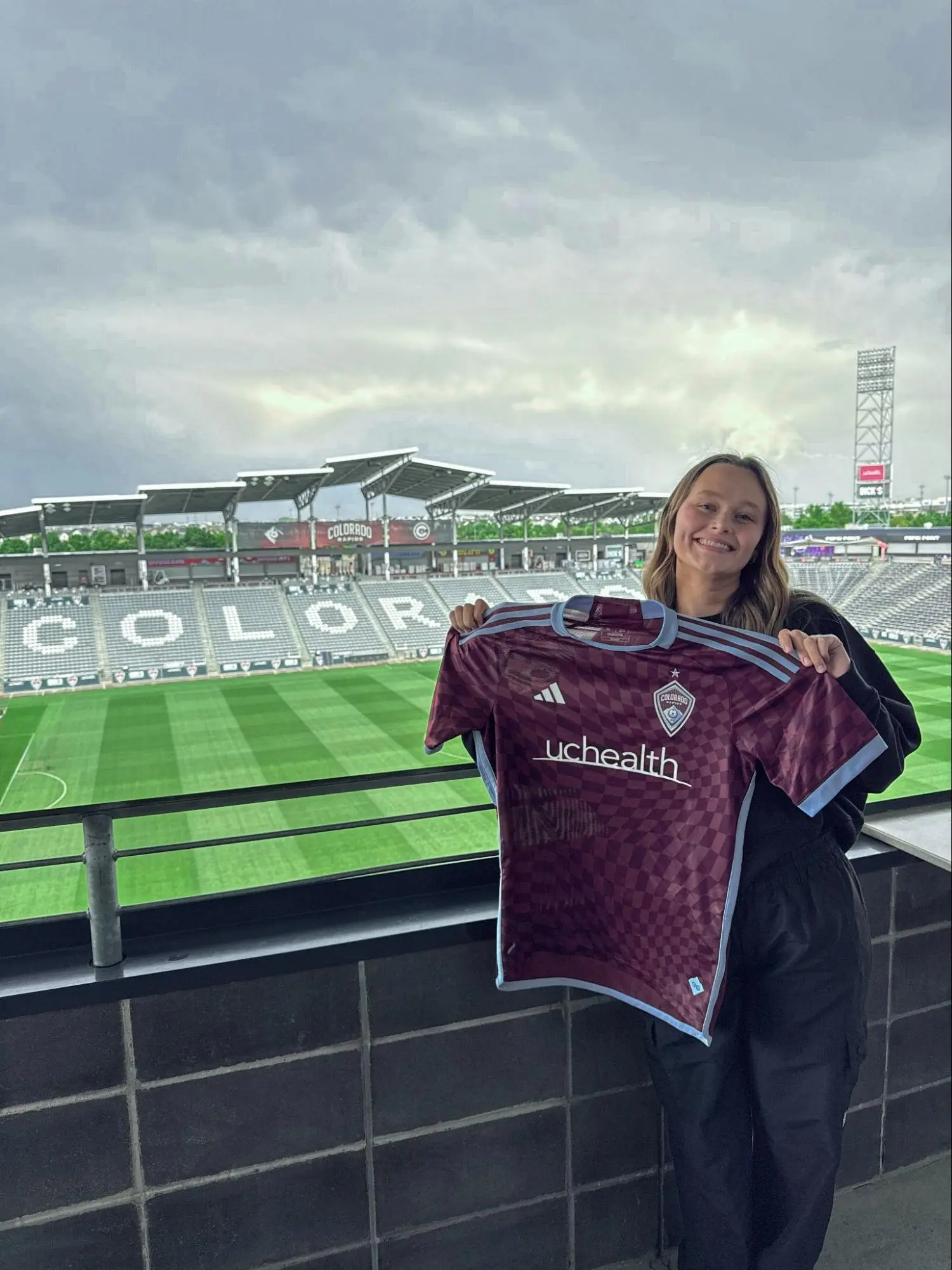 Tori Cleveland smiles holding up soccer jersey
