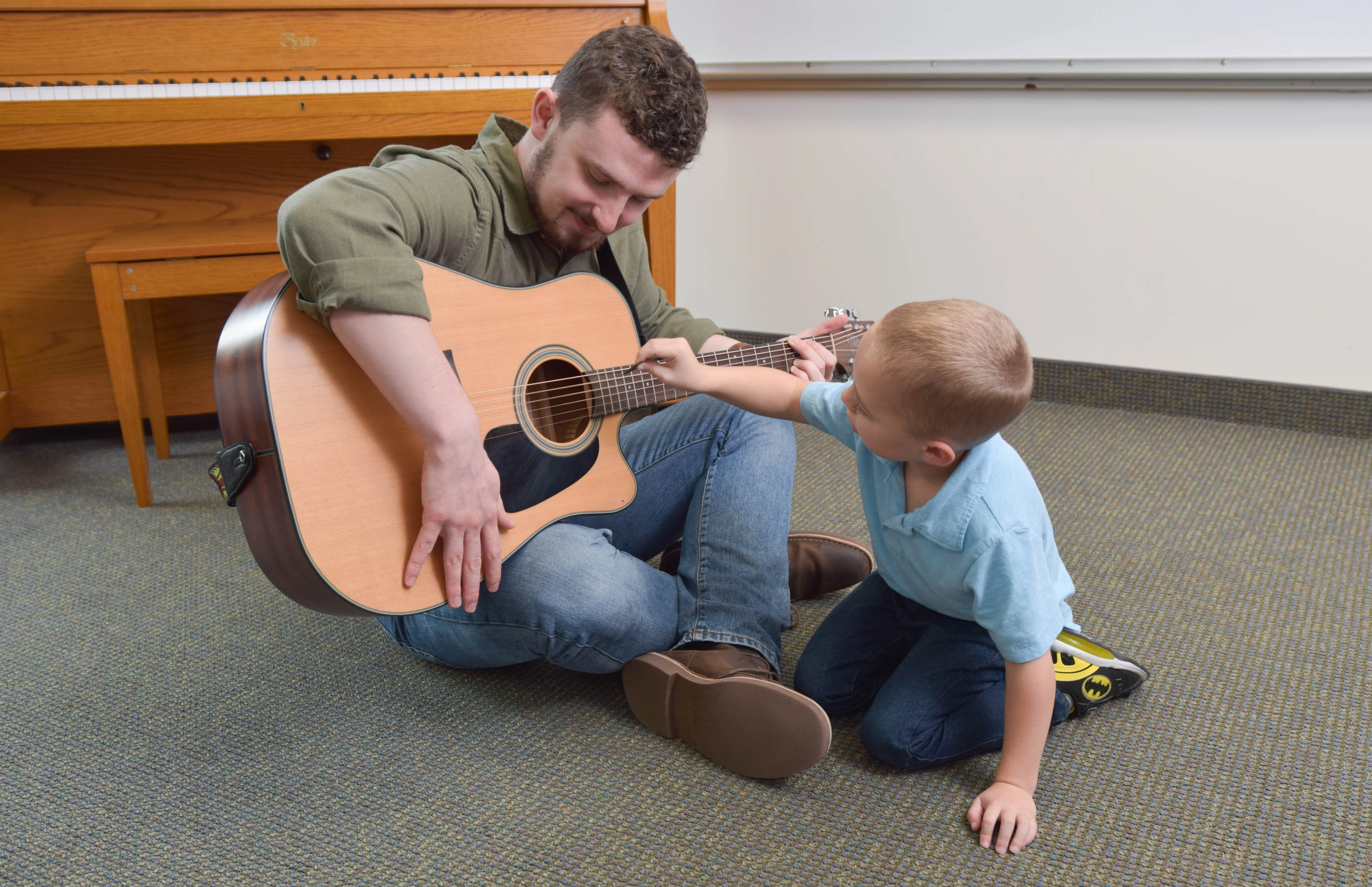 A Music Therapy student teaching a child how to play guitar